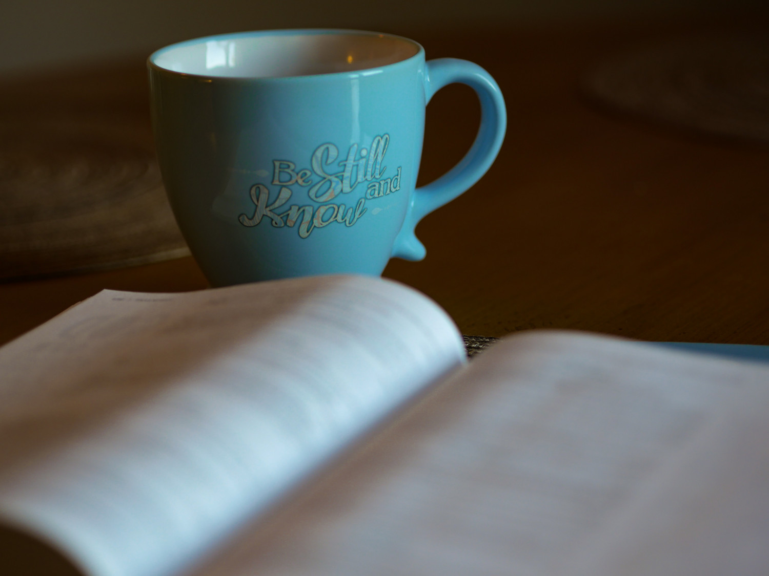 Bible and a mug with the words Be Still
