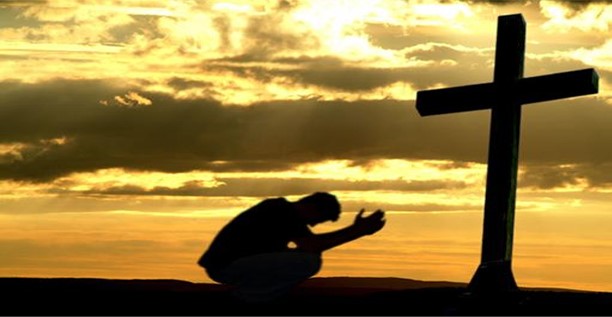 Man kneeling at foot of cross