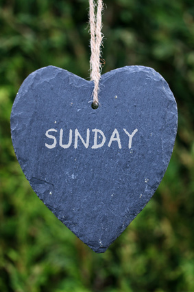 Photo of a slate hanging heart with the word 'Sunday' written on it.